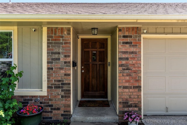 entrance to property featuring brick siding and roof with shingles