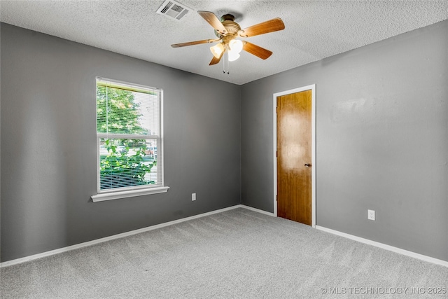 empty room featuring ceiling fan, carpet flooring, a textured ceiling, and baseboards