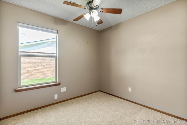 carpeted spare room with baseboards, a ceiling fan, and a textured ceiling