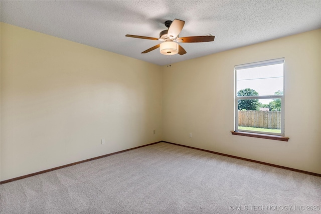 carpeted empty room featuring ceiling fan, baseboards, and a textured ceiling