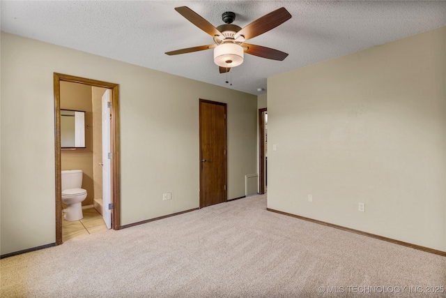 unfurnished bedroom featuring carpet flooring, baseboards, connected bathroom, a textured ceiling, and ceiling fan