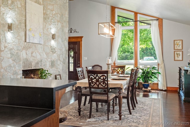 1300 S Mississippi, Ada, OK 74820 - dining area with wood finished floors, plenty of natural light, lofted ceiling, a fireplace, and baseboards