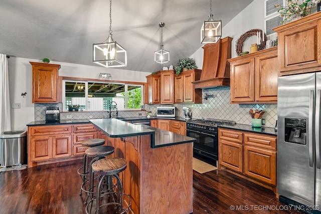 1300 S Mississippi, Ada, OK 74820 - kitchen with appliances with stainless steel finishes, dark countertops, tasteful backsplash, dark wood finished floors, and vaulted ceiling
