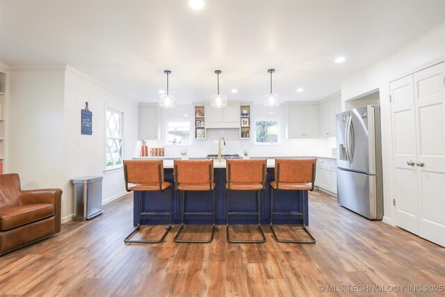 5529 S New Haven Ave, Tulsa, OK 74135 - kitchen with stainless steel fridge with ice dispenser, light countertops, white cabinetry, open shelves, and light wood-style floors