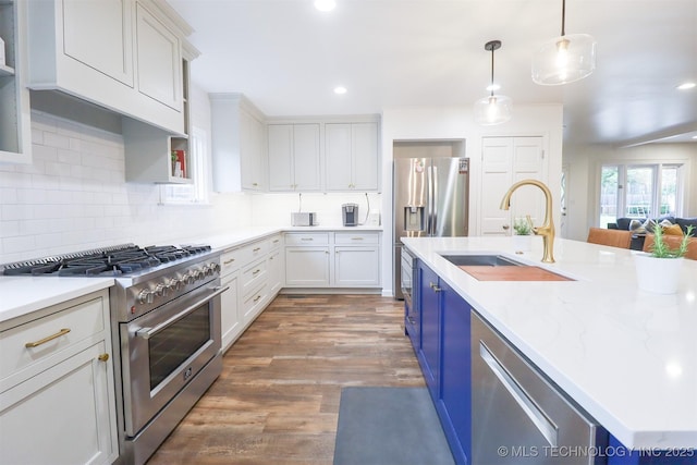 5529 S New Haven Ave, Tulsa, OK 74135 - kitchen with appliances with stainless steel finishes, a sink, white cabinets, backsplash, and decorative light fixtures