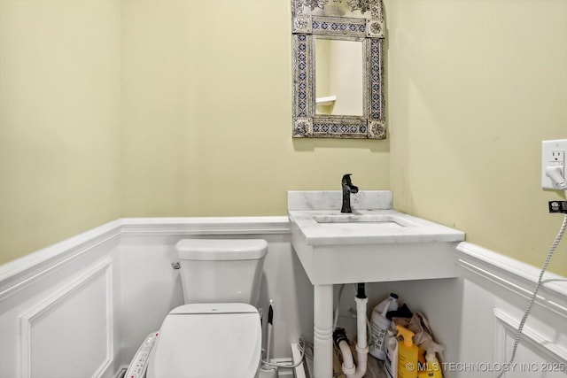 15209 S 89th W Ave, Sapulpa, OK 74066 - half bathroom featuring a wainscoted wall, toilet, and a decorative wall