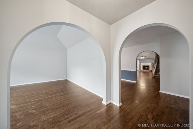 408 S Tamarack Ave, Broken Arrow, OK 74012 - unfurnished room with dark wood-style flooring, arched walkways, and vaulted ceiling