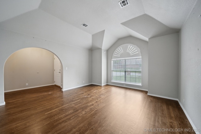 408 S Tamarack Ave, Broken Arrow, OK 74012 - unfurnished room with arched walkways, vaulted ceiling, and wood finished floors