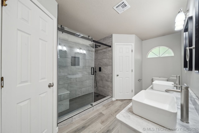 408 S Tamarack Ave, Broken Arrow, OK 74012 - bathroom featuring a shower stall, wood finished floors, and double vanity