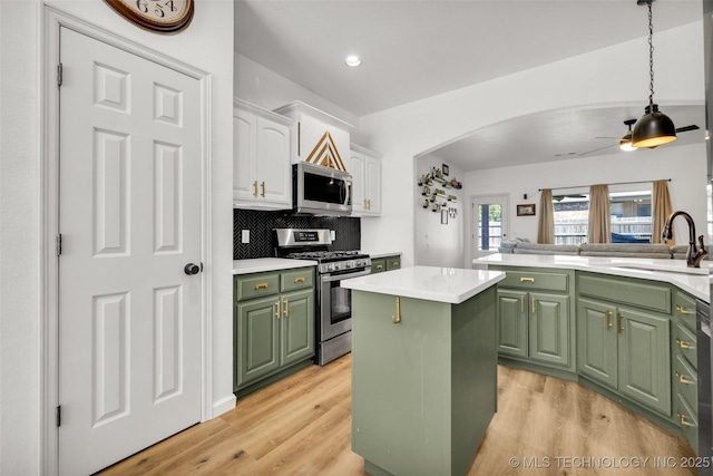 2405 S 13th St, Broken Arrow, OK 74012 - kitchen with green cabinetry, appliances with stainless steel finishes, a sink, white cabinets, and a center island