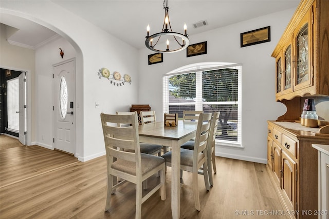 2405 S 13th St, Broken Arrow, OK 74012 - dining area featuring arched walkways, light wood-style floors, a chandelier, baseboards, and crown molding