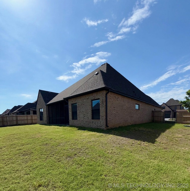 14503 E 80th St N, Owasso, OK 74055 - back of house featuring brick siding, a shingled roof, and a sunroom