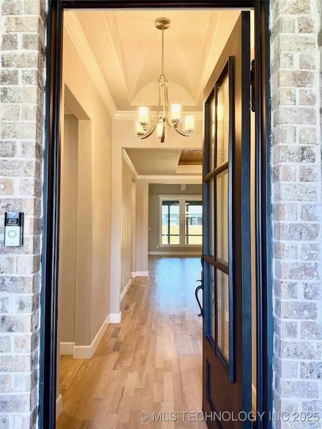 14503 E 80th St N, Owasso, OK 74055 - hall with crown molding, a chandelier, light wood-style floors, baseboards, and brick wall