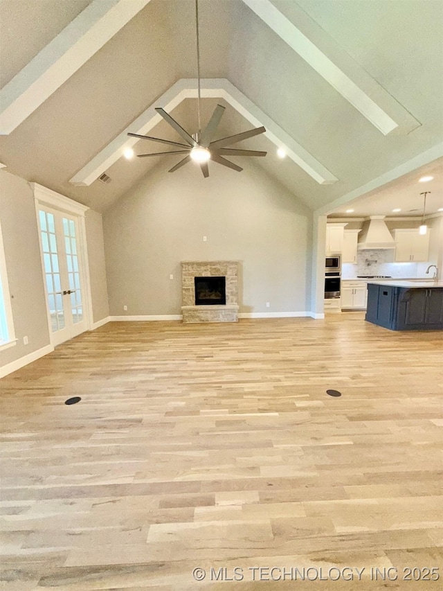 14503 E 80th St N, Owasso, OK 74055 - unfurnished living room featuring a sink, beam ceiling, ceiling fan, baseboards, and high vaulted ceiling