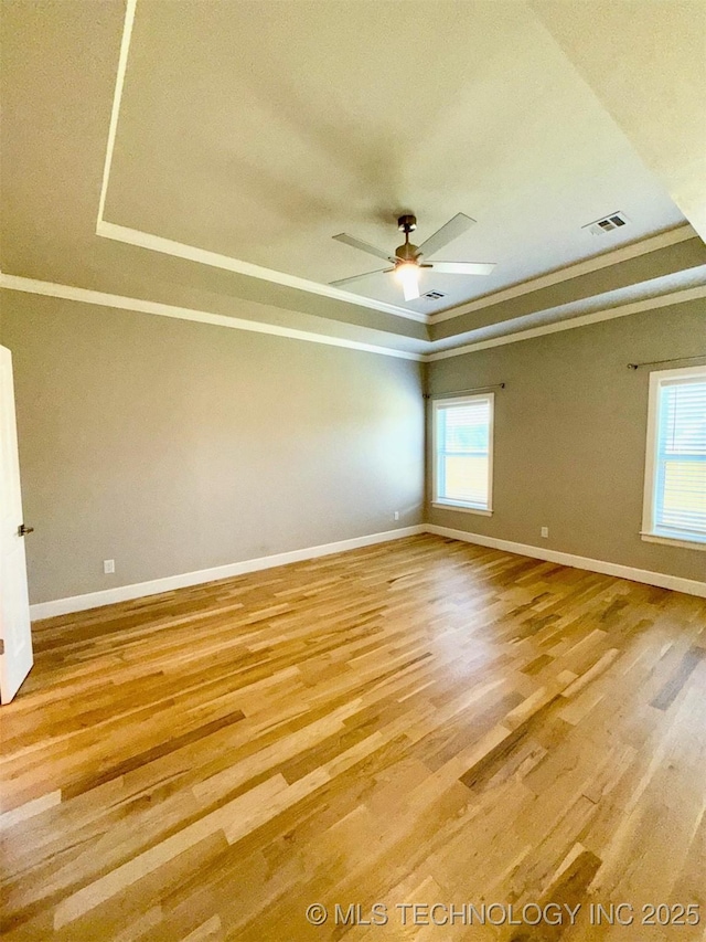 14503 E 80th St N, Owasso, OK 74055 - spare room with a raised ceiling, baseboards, crown molding, and light wood-style flooring