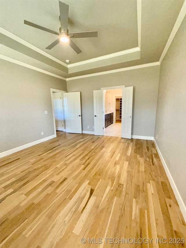 14503 E 80th St N, Owasso, OK 74055 - unfurnished bedroom with crown molding, a raised ceiling, light wood-style flooring, and baseboards