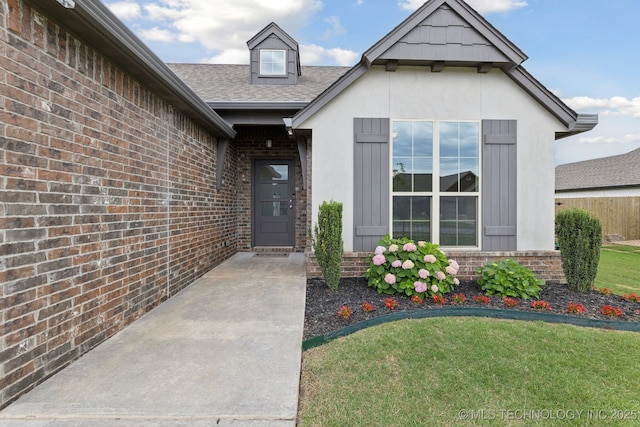 23012 E 104th St S, Broken Arrow, OK 74014 - entrance to property featuring roof with shingles, a yard, and brick siding