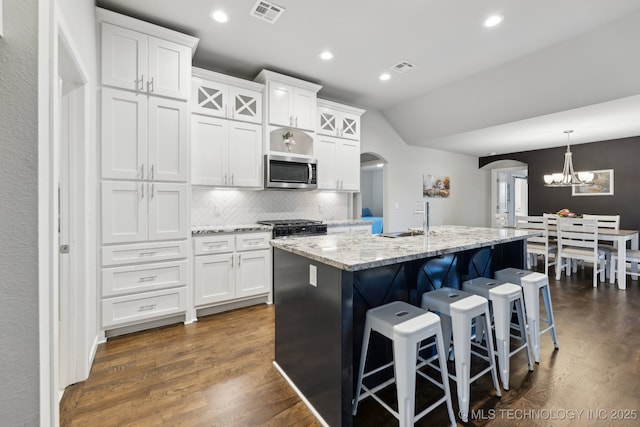 23012 E 104th St S, Broken Arrow, OK 74014 - kitchen featuring stainless steel microwave, arched walkways, lofted ceiling, a chandelier, and a sink