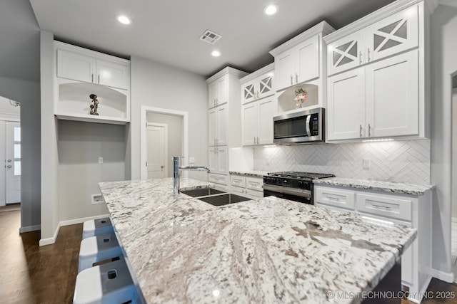 23012 E 104th St S, Broken Arrow, OK 74014 - kitchen with stainless steel microwave, gas stove, a sink, tasteful backsplash, and an island with sink