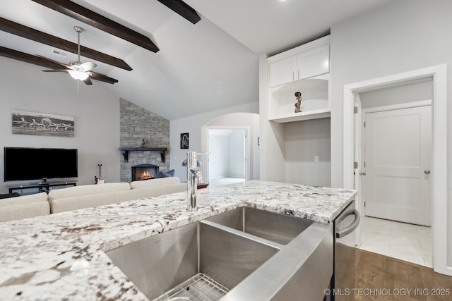 23012 E 104th St S, Broken Arrow, OK 74014 - kitchen featuring a sink, open floor plan, a fireplace, ceiling fan, and light stone countertops