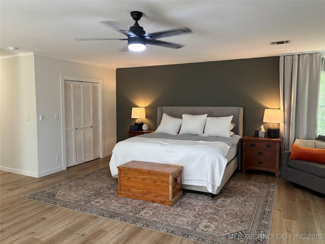 1113 S Meadow Dr, Ardmore, OK 73401 - bedroom featuring wood finished floors, ornamental molding, a ceiling fan, baseboards, and a closet
