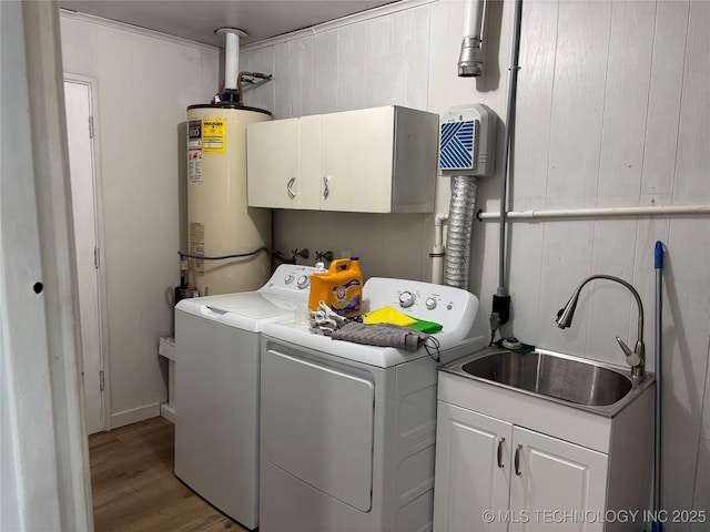 1113 S Meadow Dr, Ardmore, OK 73401 - washroom with washing machine and dryer, water heater, cabinet space, and wood finished floors