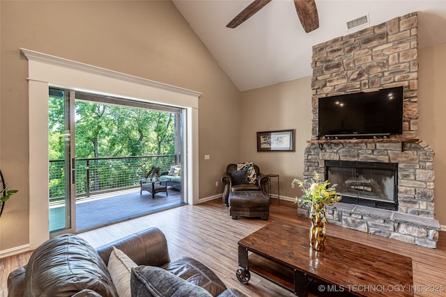 11802 Hickory Ln, Claremore, OK 74017 - living room featuring wood finished floors, a ceiling fan, high vaulted ceiling, and a stone fireplace