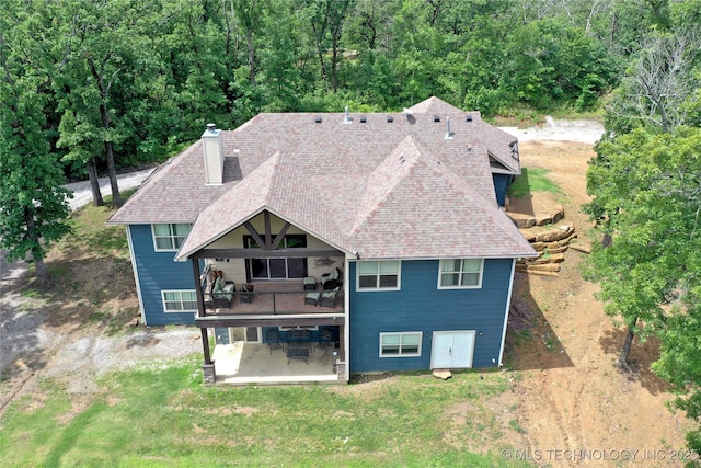 11802 Hickory Ln, Claremore, OK 74017 - rear view of house featuring a patio, a lawn, roof with shingles, and a chimney