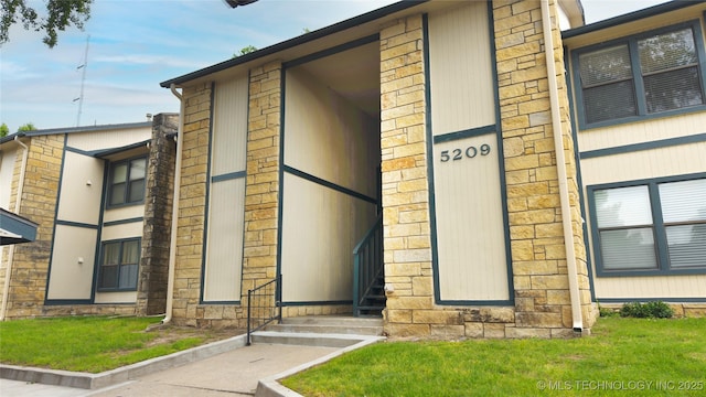 5209 SE Nowata Rd Unit 104B, Bartlesville, OK 74006 - entrance to property featuring stone siding and a lawn