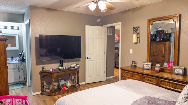 5209 SE Nowata Rd Unit 104B, Bartlesville, OK 74006 - bedroom with wood finished floors, a textured ceiling, ensuite bath, and baseboards