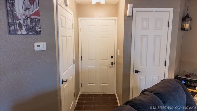 5209 SE Nowata Rd Unit 104B, Bartlesville, OK 74006 - doorway to outside featuring dark tile patterned flooring and a textured wall