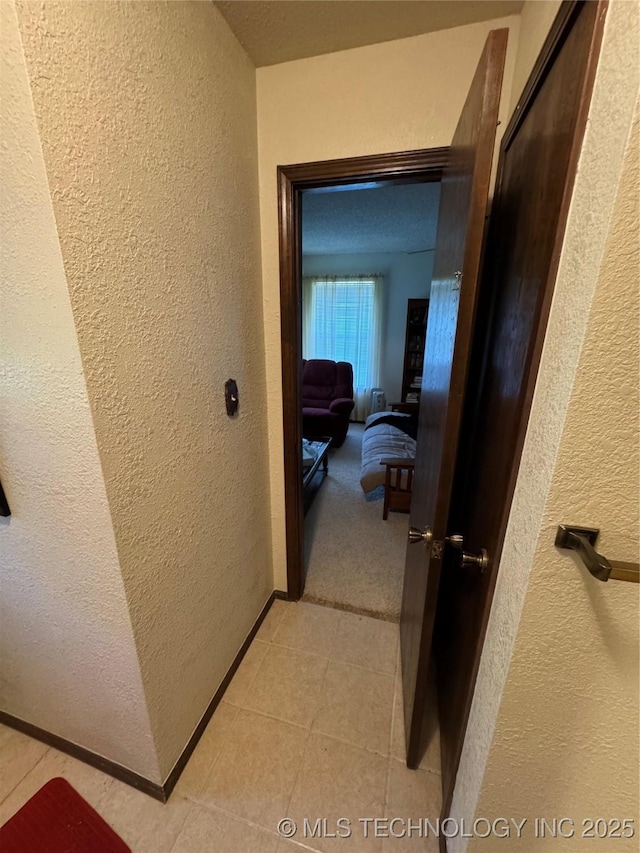 50 Fairway, Burneyville, OK 73430 - hallway with a textured wall, light tile patterned floors, and baseboards