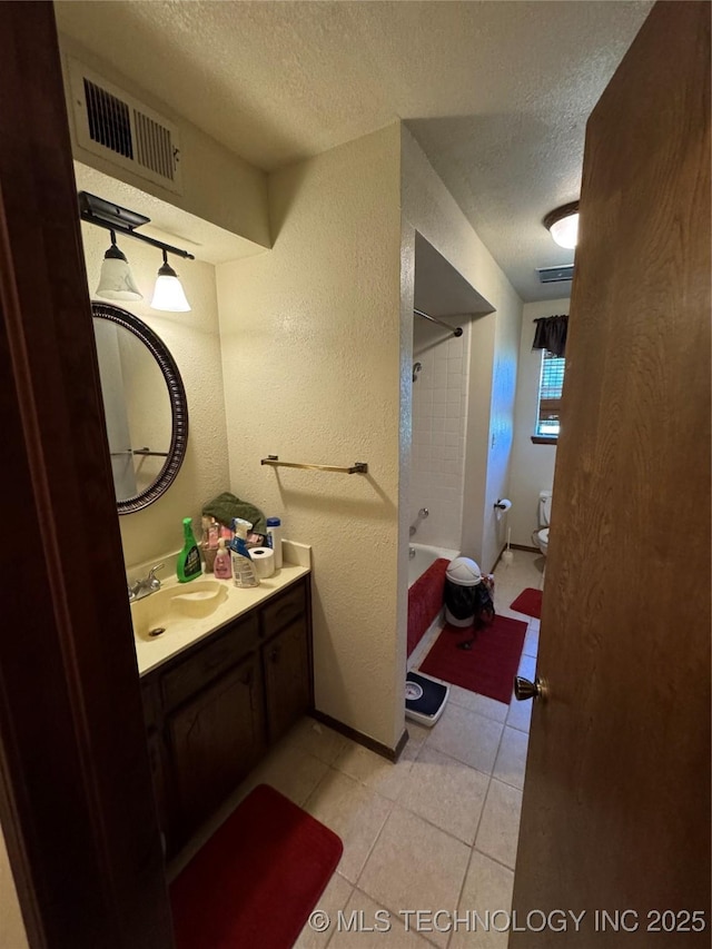 50 Fairway, Burneyville, OK 73430 - bathroom featuring a textured ceiling, vanity, toilet, tile patterned floors, and a textured wall