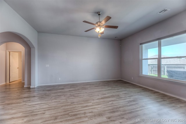 25363 E 87th St S, Broken Arrow, OK 74014 - unfurnished room featuring light wood-type flooring, a ceiling fan, arched walkways, and baseboards