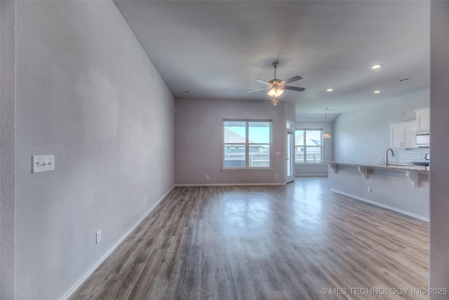25363 E 87th St S, Broken Arrow, OK 74014 - unfurnished living room with wood finished floors, baseboards, a ceiling fan, and recessed lighting