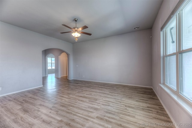 25363 E 87th St S, Broken Arrow, OK 74014 - spare room featuring ceiling fan, arched walkways, wood finished floors, and baseboards