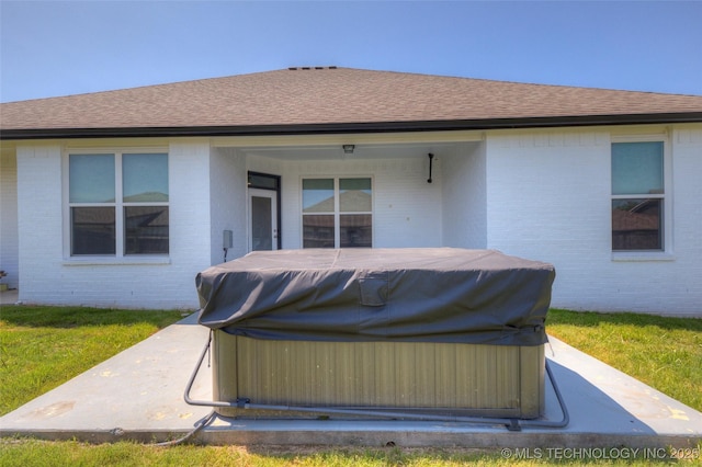 25363 E 87th St S, Broken Arrow, OK 74014 - back of property featuring a hot tub, brick siding, roof with shingles, and a patio area