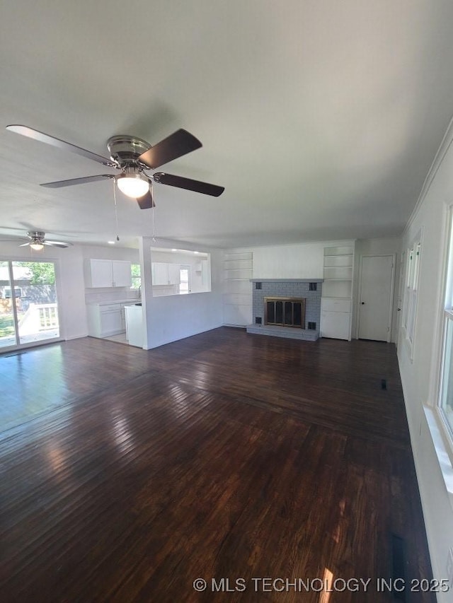 700 S Apple St, Sapulpa, OK 74066 - unfurnished living room featuring a fireplace, wood finished floors, and ceiling fan