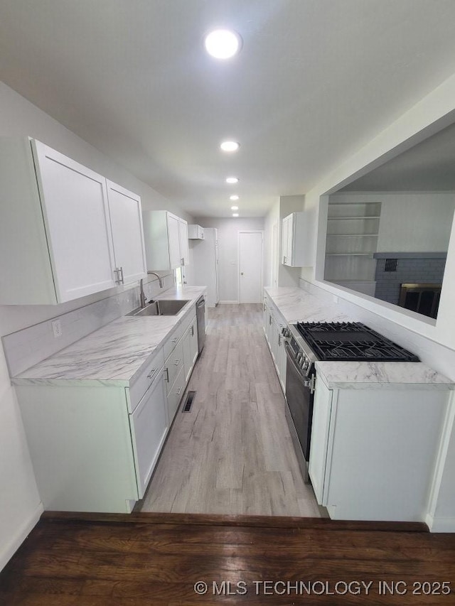 700 S Apple St, Sapulpa, OK 74066 - kitchen featuring a sink, appliances with stainless steel finishes, light wood-style floors, white cabinets, and recessed lighting