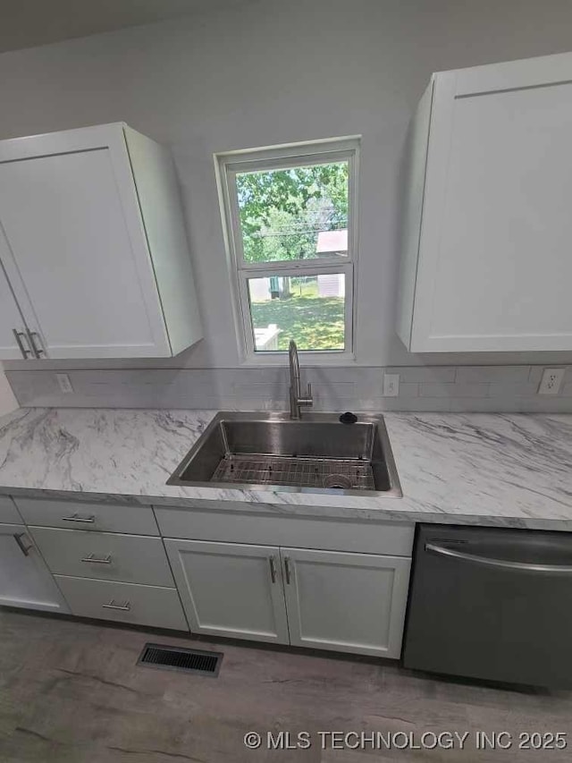 700 S Apple St, Sapulpa, OK 74066 - kitchen featuring a sink, stainless steel dishwasher, white cabinetry, and light stone countertops