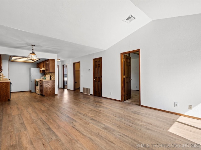 5217 Nowata Rd Unit C204, Bartlesville, OK 74006 - unfurnished living room with lofted ceiling, wood finished floors, and baseboards