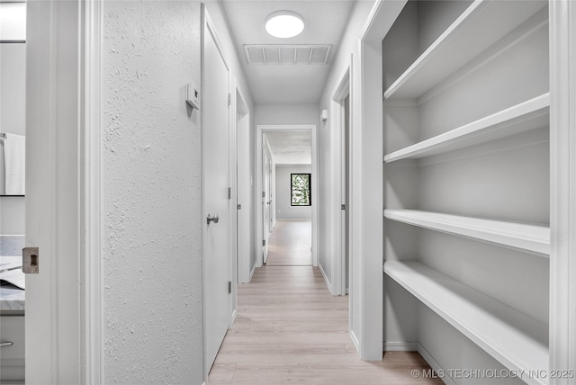 1602 N Hickory Ave, Broken Arrow, OK 74012 - hallway with light wood finished floors, a textured wall, and baseboards