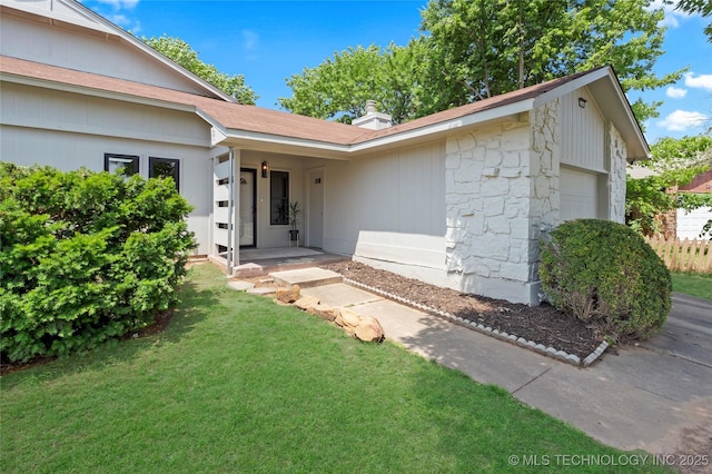 1602 N Hickory Ave, Broken Arrow, OK 74012 - property entrance with stone siding, a yard, a chimney, and an attached garage