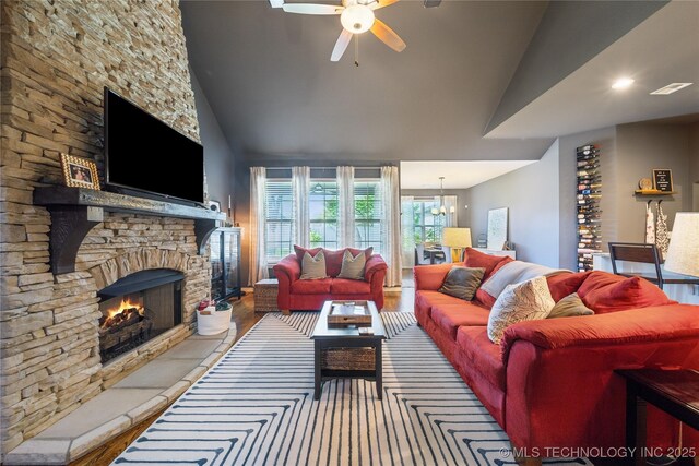18409 E 50th Pl S, Tulsa, OK 74134 - living room with a ceiling fan, a stone fireplace, high vaulted ceiling, and a chandelier