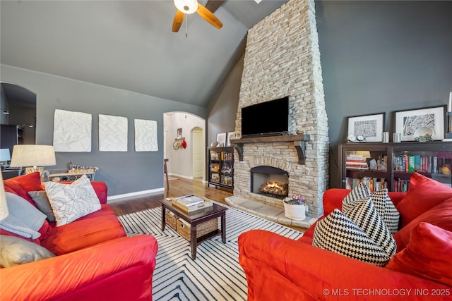 18409 E 50th Pl S, Tulsa, OK 74134 - living room featuring a ceiling fan, arched walkways, wood finished floors, a stone fireplace, and baseboards