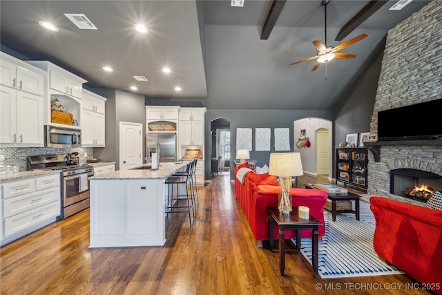 18409 E 50th Pl S, Tulsa, OK 74134 - kitchen featuring appliances with stainless steel finishes, arched walkways, a ceiling fan, open floor plan, and white cabinets