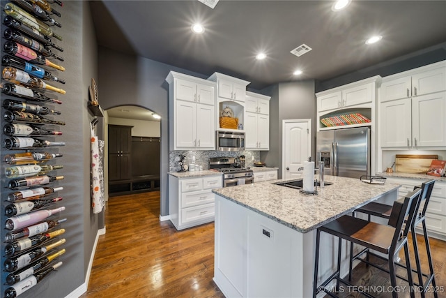 18409 E 50th Pl S, Tulsa, OK 74134 - kitchen with stainless steel appliances, recessed lighting, a breakfast bar area, white cabinets, and backsplash
