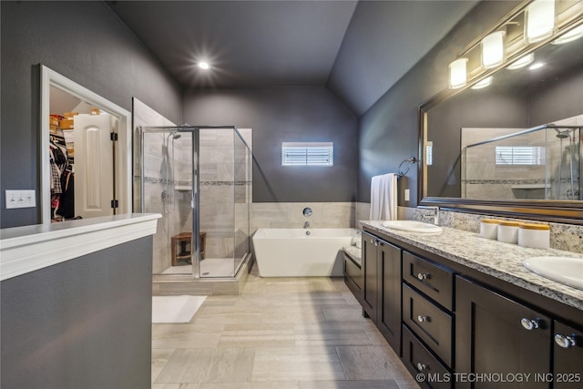 18409 E 50th Pl S, Tulsa, OK 74134 - bathroom with a freestanding tub, a stall shower, double vanity, a walk in closet, and vaulted ceiling