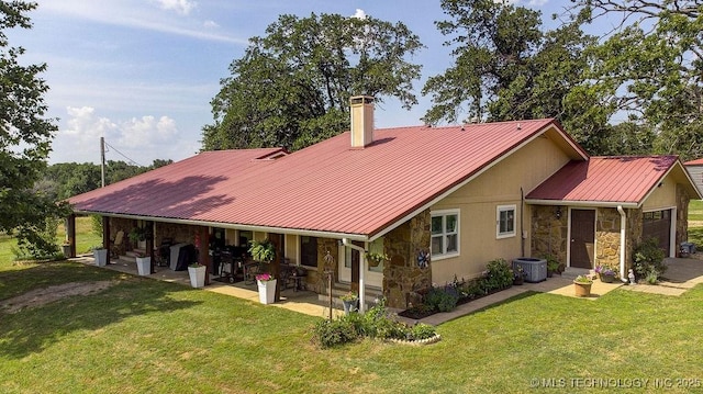 20700 E 420th Rd, Claremore, OK 74017 - rear view of property featuring stone siding, a lawn, a chimney, a metal roof, and a patio area