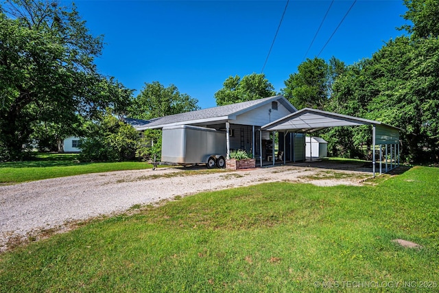 506 S 8th, Davis, OK 73030 - rear view of property with gravel driveway, a yard, a carport, and an outbuilding